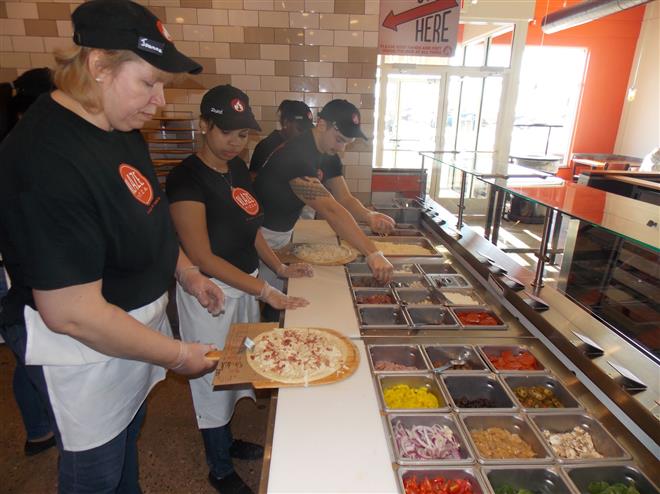 Pizzas are made to order along an assembly line at Blaze Pizza in Brookfield.
