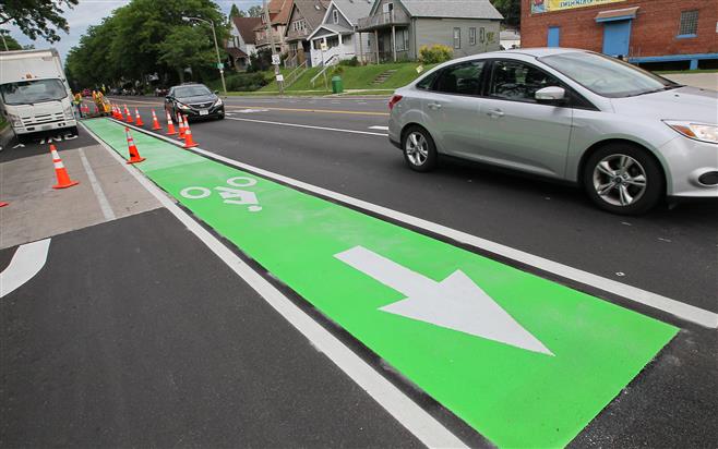 The green plastic panels are bonded to the asphalt to denote a high conflict location where bikes and cars are both turning and need to be made more aware of each other.
