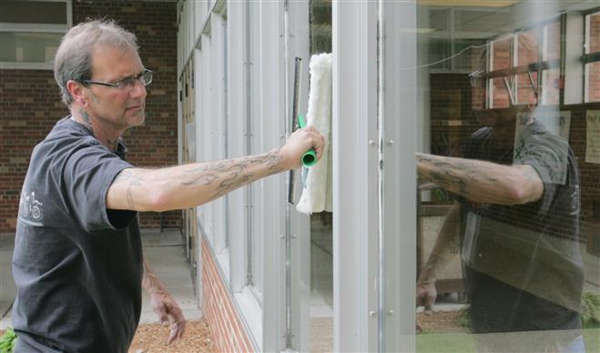 Steve Domurat, a 23-year veteran of cleaning and maintaining Wauwatosa Public Schools, will be part of the district's plan to layoff half of the custodial staff and hire contractors to clean the schools. Domurat is cleaning windows outside of Underwood Elementary School where he is currently assigned.