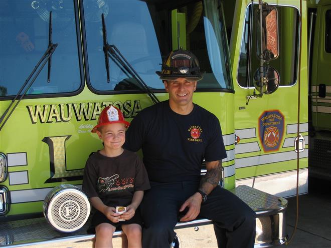 Tony SanFelippo sits on a Wauwatosa firetruck with his nephew. He was terminated from the department earlier this year and is fighting the city for disability benefits. Photo submitted by Tony SanFelippo.