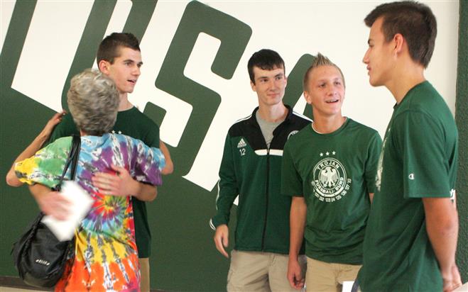 Denise Schneidler hugs Alex Stanisic as he and Nick Stanisic, Alex Wimmer and Sage Schram (right) were recognized for coming to the aid of Schneidler’s daughter, Nicole Kastner, when she collapsed in front of the home of her daycare provider.