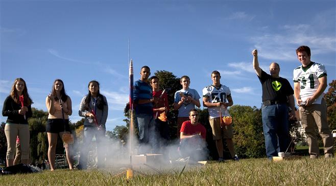 Wauwatosa West High School aerospace engineering students watch as a model rocket leaves its launch pad on the athletic field next to Underwood Elementary School on Friday.