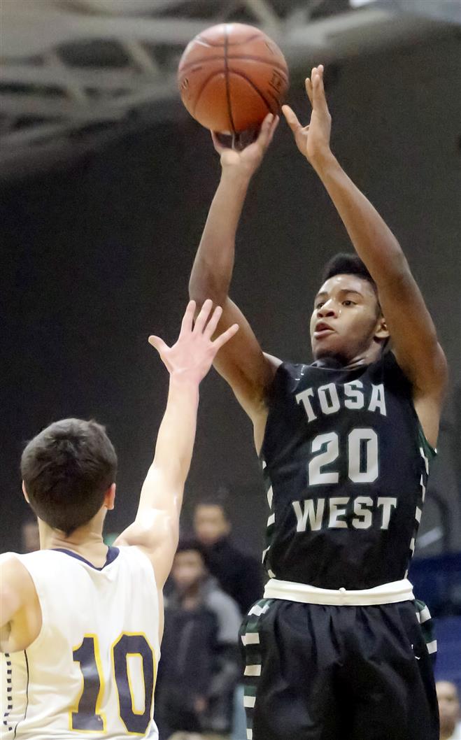 Andre Carroll of Wauwatosa West launches a shot over Brendan Bullock at Pius on Friday. The Trojans’ 50-47 loss snapped their six-game winning streak.