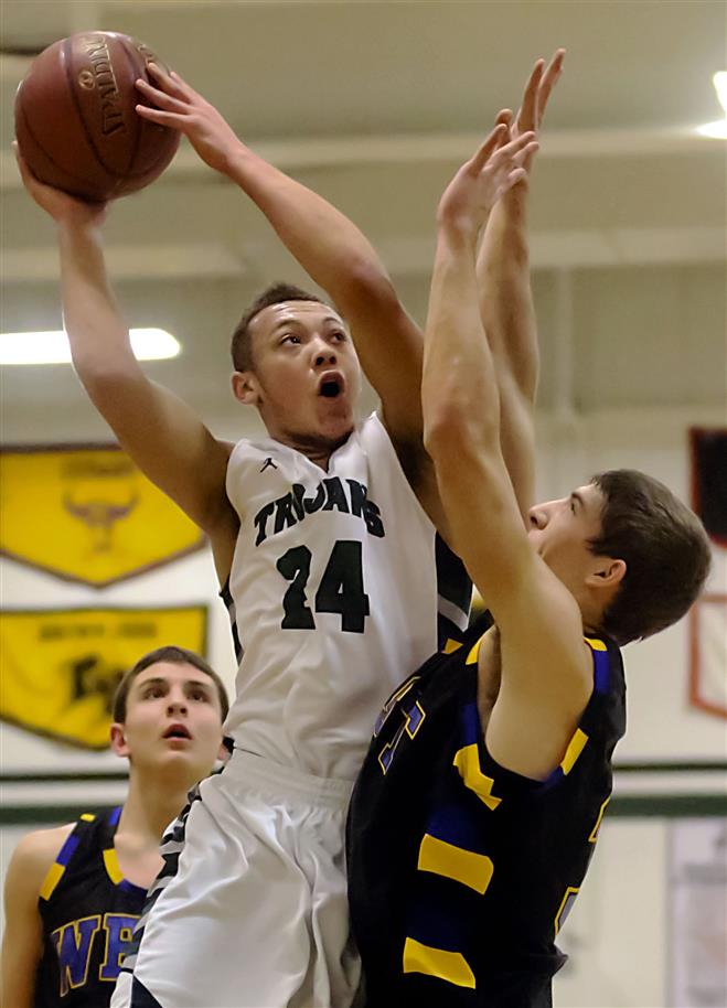 Steffan Brown of Wauwatosa West makes a move to the basket against New Berlin West’s Scott Reichel in the Trojans’ 76-55 win on Friday at home.