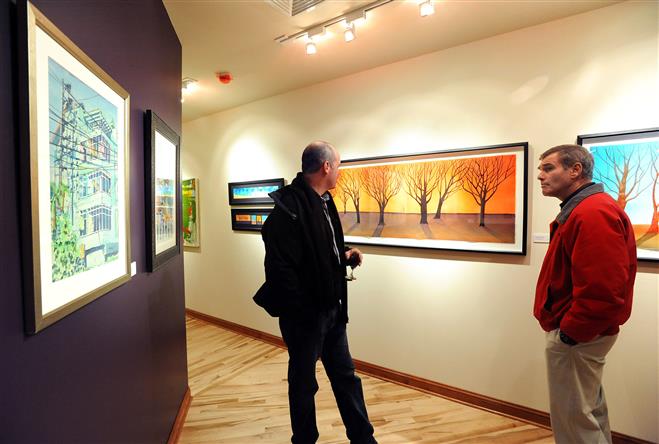 Kevin Murray (left) and Rob Heyrman peruse the artwork on display on the second floor of Bridgetowne Custom Framing on Jan. 31. Bridgetowne held its first art show in its newly renovated second floor.