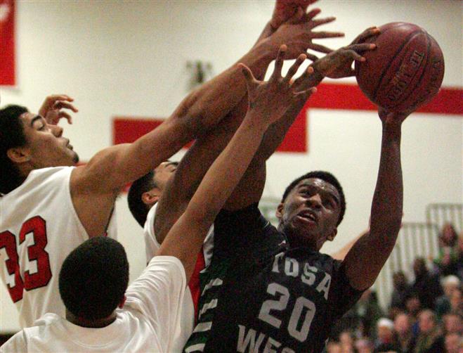 Wauwatosa West’s Andre Carroll rebounds on Saturday. The junior guard scored 18 points in the loss to Tosa East.