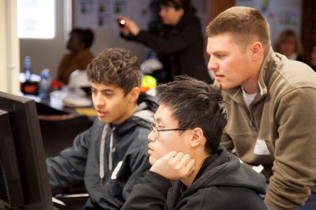 Bob Amstadt of Mortenson Construction watches Bradley Tech students  Quangdao  Nguyen (center) and  Justice York as they work on an AutoCAD scheduling system at the Froedtert construction site.