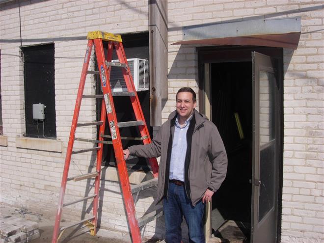 Joshua Jeffers stands behind the soon-to-be Hue Vietnamese Cuisine at 65th Street and North Avenue, a historic building he is currently restoring.