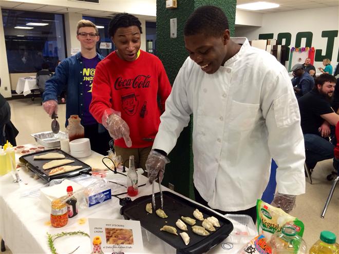 Joey Rampolla (left), Justin Gutter and Carlos Morris serve food at the multicultural fair at Wauwatosa West High School.
