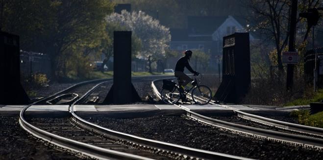 A file photo from April 4, 2012, shows a bicyclist rolling across a pedestrian railroad crossing in the village area of Wauwatosa.