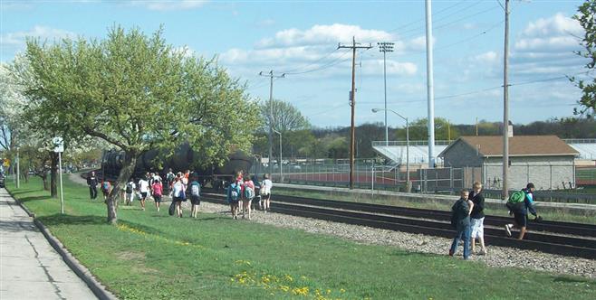 Students at Wauwatosa East High School dangerously cross the tracks while a train approaches.