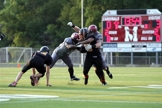 Spartan defensive end Joe Flick and linebacker Kevin Morris combine to wrap up Monona running back Darwin Hoye.