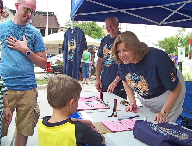 Neighborhood Watch Committee members Harry Kohal and Diana Barkow advertise Tosa’s Night Out at the Tosa Farmers Market on May 26.