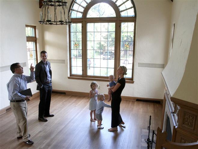 Doug Sprague (left) of Firefly Real Estate shows the Fleming family a home in Wauwatosa last week that they were considering.