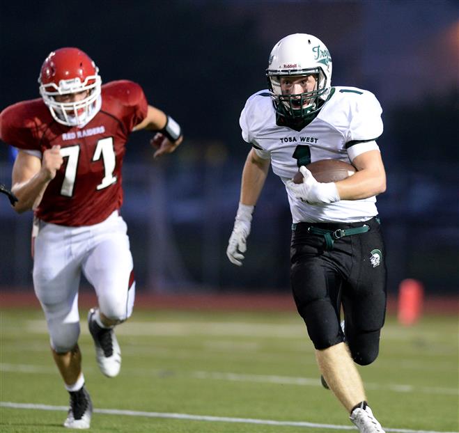 Wauwatosa West running back Truman Tyson turns the corner as Wauwatosa East defensive lineman Eric Brzezinski gives chase. West won, 42-7, on Aug. 22 at Hart Park in Wauwatosa.