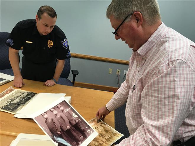 Sgt. Brad Beckman, left, watches as Chief Barry Weber handles old photographs of the Wauwatosa Police Department's first officers March 8. The police department celebrated its 100th anniversary April 18.