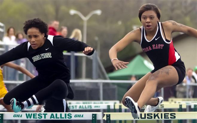 Kayla Crump of Wauwatosa West (left) and Wauwatosa East’s Cyntala Glass race side-by-side in a 100-meter hurdles heat at the West Allis Hale Invitational track meet on May 13. Due to a timing problem, no official results were available.