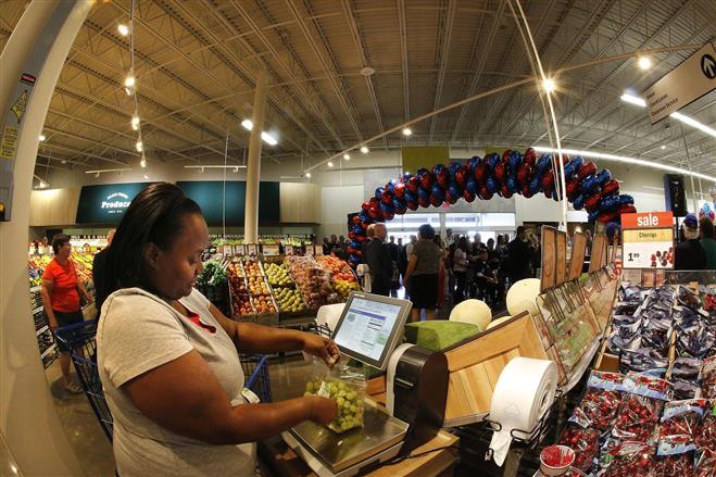 Carlotta Tyler, of Milwaukee, Wisconsin, weighs grapes she was buying in the newly opened Meiger store Tuesday, Aug. 4, 2015, in Wauwatosa. Meijer has launched its Simply Give campaign to benefit food pantries in southeastern Wisconsin.