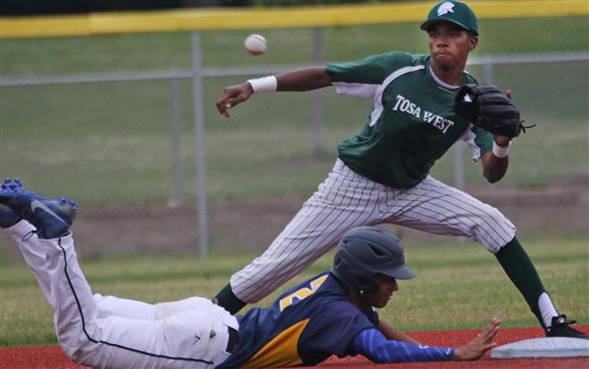 Whitnall’s Jonathan Reed dives back to second base on a pick-off attempt as Wauwatosa West’s LeRoy Coleman tries for the tag during their game June 16 at Breitlow Field. The Falcons won, 7-0.