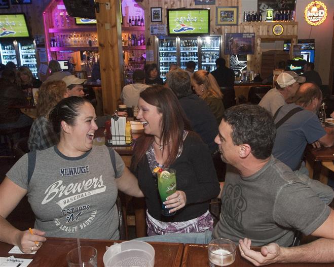 Jennine Paoli (center) talks to patrons April and Glen Blok at Saloon on Calhoun with Bacon. Members of the trivia team "Epic,", they come on Mondays for the weekly team trivia night. Glen said "it's the best sports bar in Brookfield."