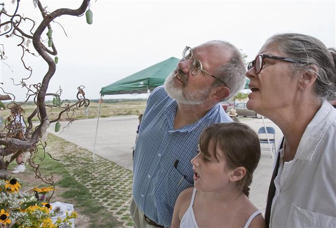 Marlena Green and her grandparents, Bobbie Groth and Don Lawson, look at monarch butterflies in chrysalis form. The living display was part of the Blue Moon Event on Aug. 31.