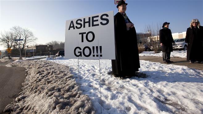 (From left) Rev. Gary Manning, Rev. Jim Rand and Trinity Episcopal Church Deacon Coleen Smith stand at the intersection of Wauwatosa and Harmonee Avenues on Wednesday in Wauwatosa. Several local priests, reverends, and pastors were spending the day applying ashes on the second annual Ashes To Go observance of Ash Wednesday.