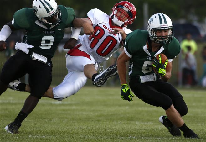 Wauwatosa West's Greg Lewis (left) blocks Wauwatosa East's Ross Janis (80) as West's Jameson Brock charges down the sideline in the first half.