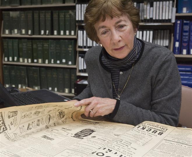 Jeanette McArthur looks through bound copies of the Wauwatosa News and Wauwatosa Times 1947 issues in a Public Libary  backroom. She's looking for obituaries and indexing them on a spreadsheet on Jan. 21.